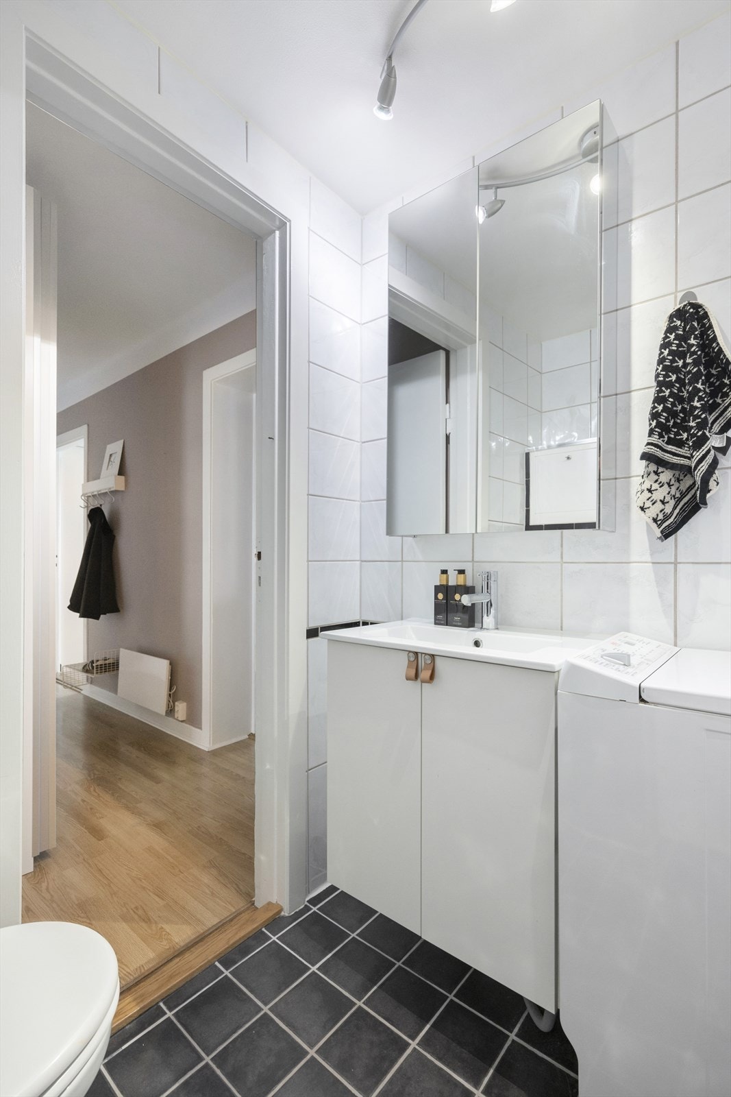 Badet er innredet med benkeskap med glatte fronter og veggskap med speilfronter. Galleribilde