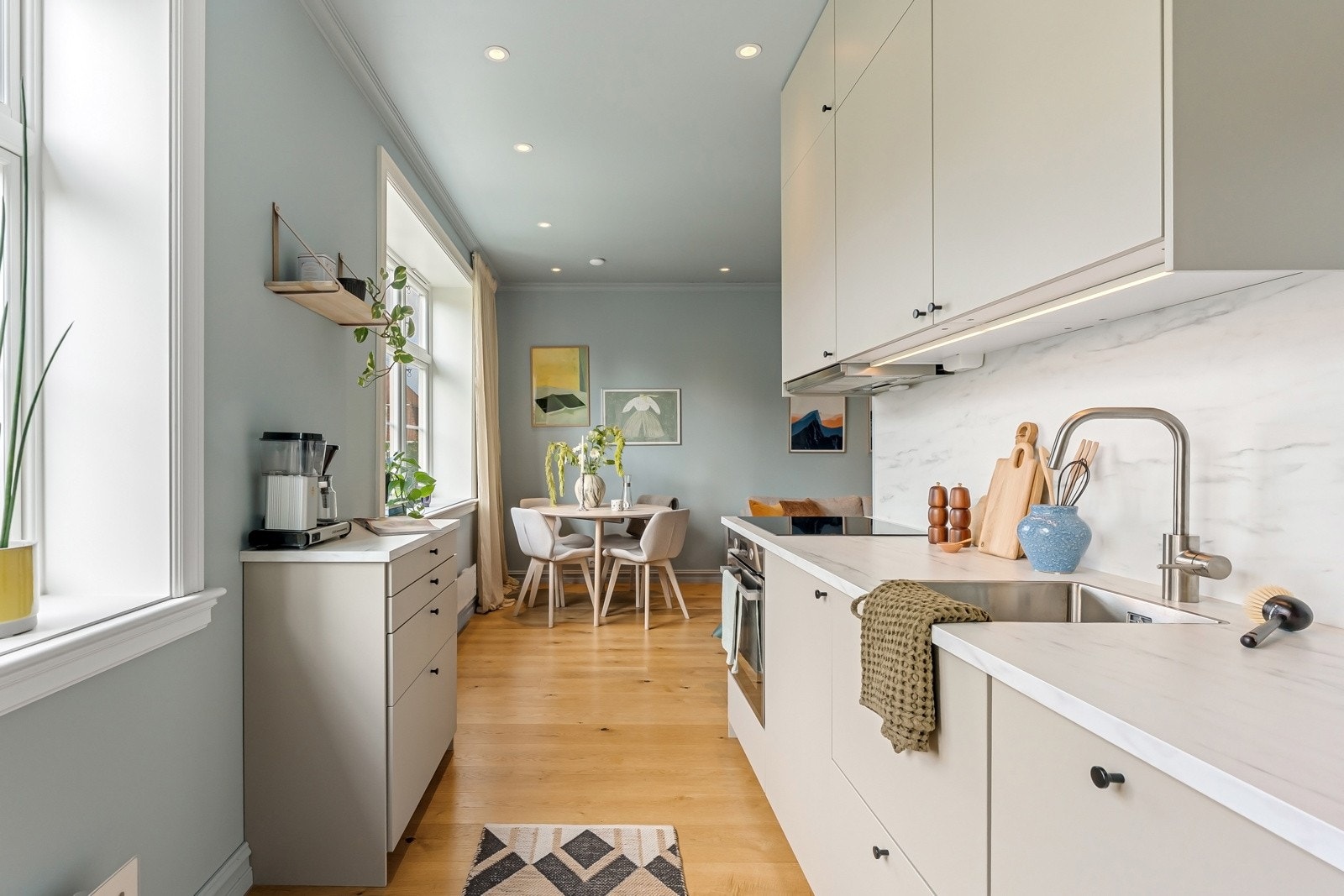 Kjøkkenet har integrerte hvitevarer som induksjonsplatetopp, stekeovn, oppvaskmaskin og kjøle/fryseskap Galleribilde