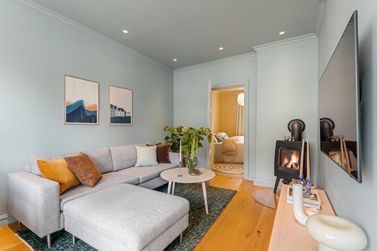 Hyggelig peis i stuens hjørne som varmer godt på kalde dager, og skaper en hyggelig lun atmosfære Galleribilde