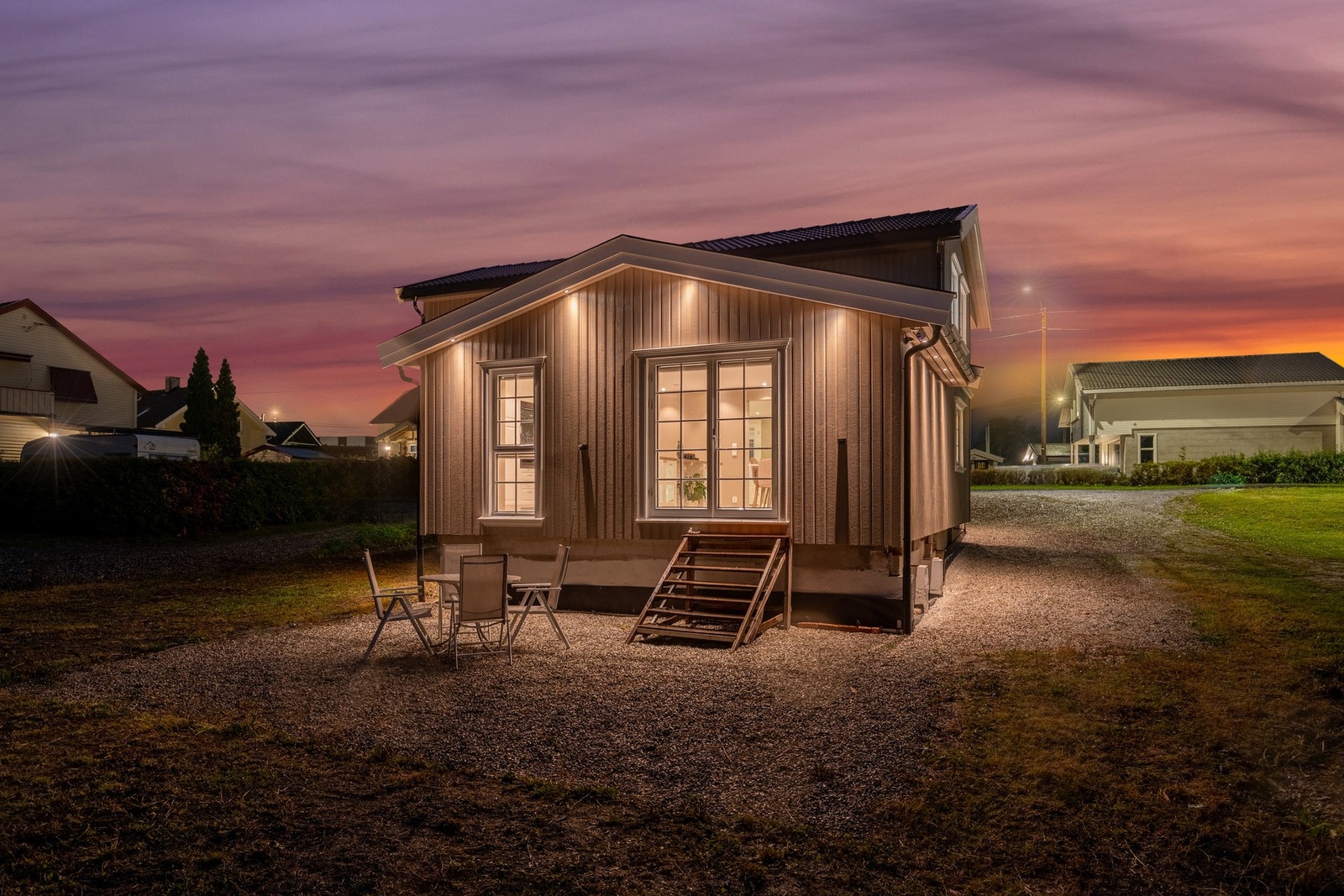 Tomten er opparbeidet med gruset uteplass, gressplen og beplantning Galleribilde