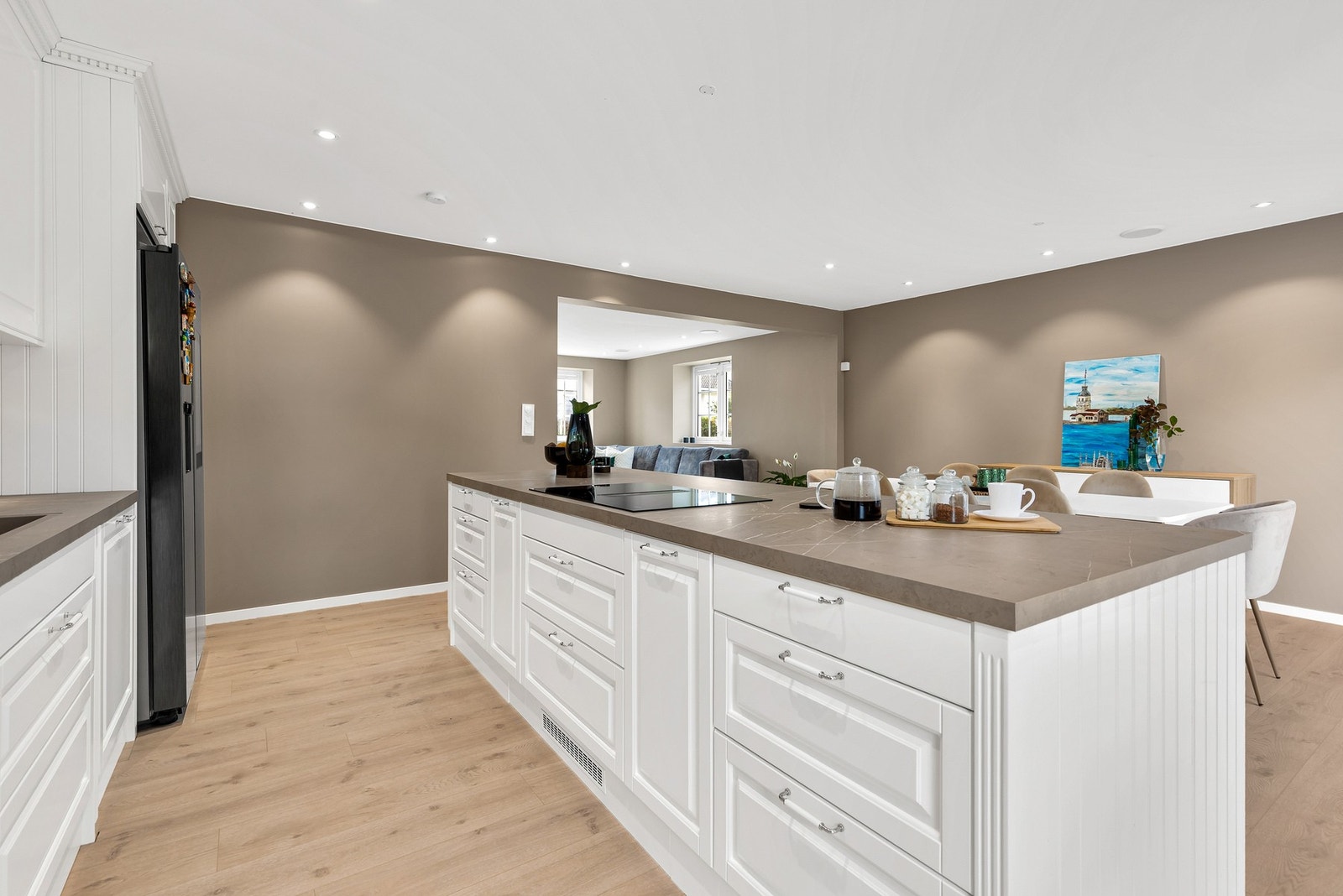 Sentralt i rommet er det montert en praktisk kjøkkenøy som gir ytterligere skap- og benkeplass Galleribilde