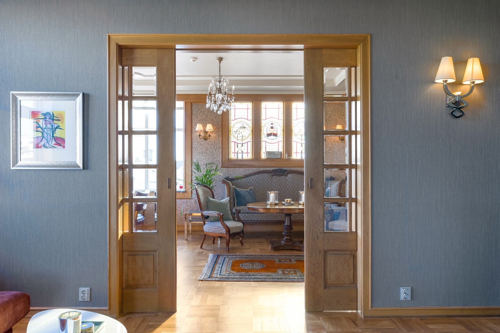 Doble dører av tre med glass fører deg videre til tv-stuen Galleribilde