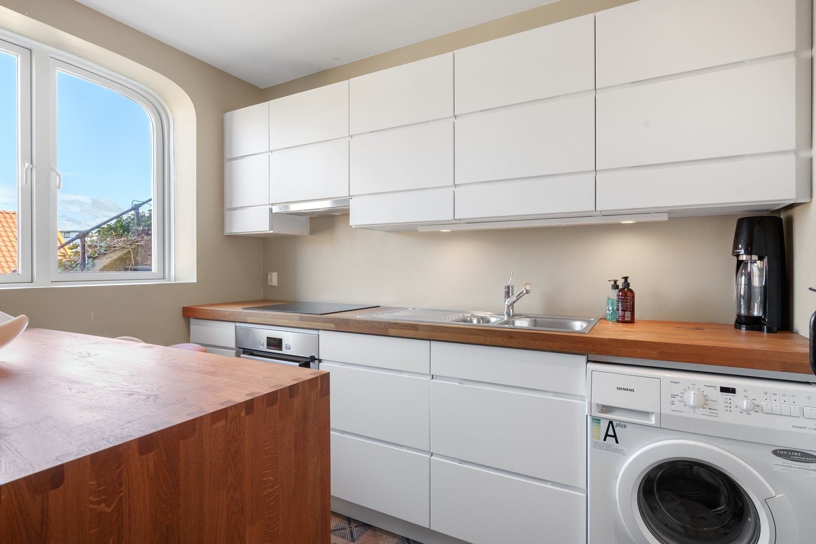 Kjøkken med inngang fra stuen. Fullt utstyrt kjøkken med vaskemaskin. Galleribilde