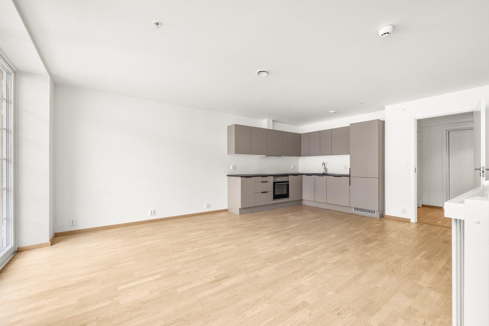 Leiligheten har god standard med parkett på gulv, lyse overflater og moderne innredning på kjøkken og bad. Det er god plass til et stort spisebord ved kjøkkenet. Galleribilde