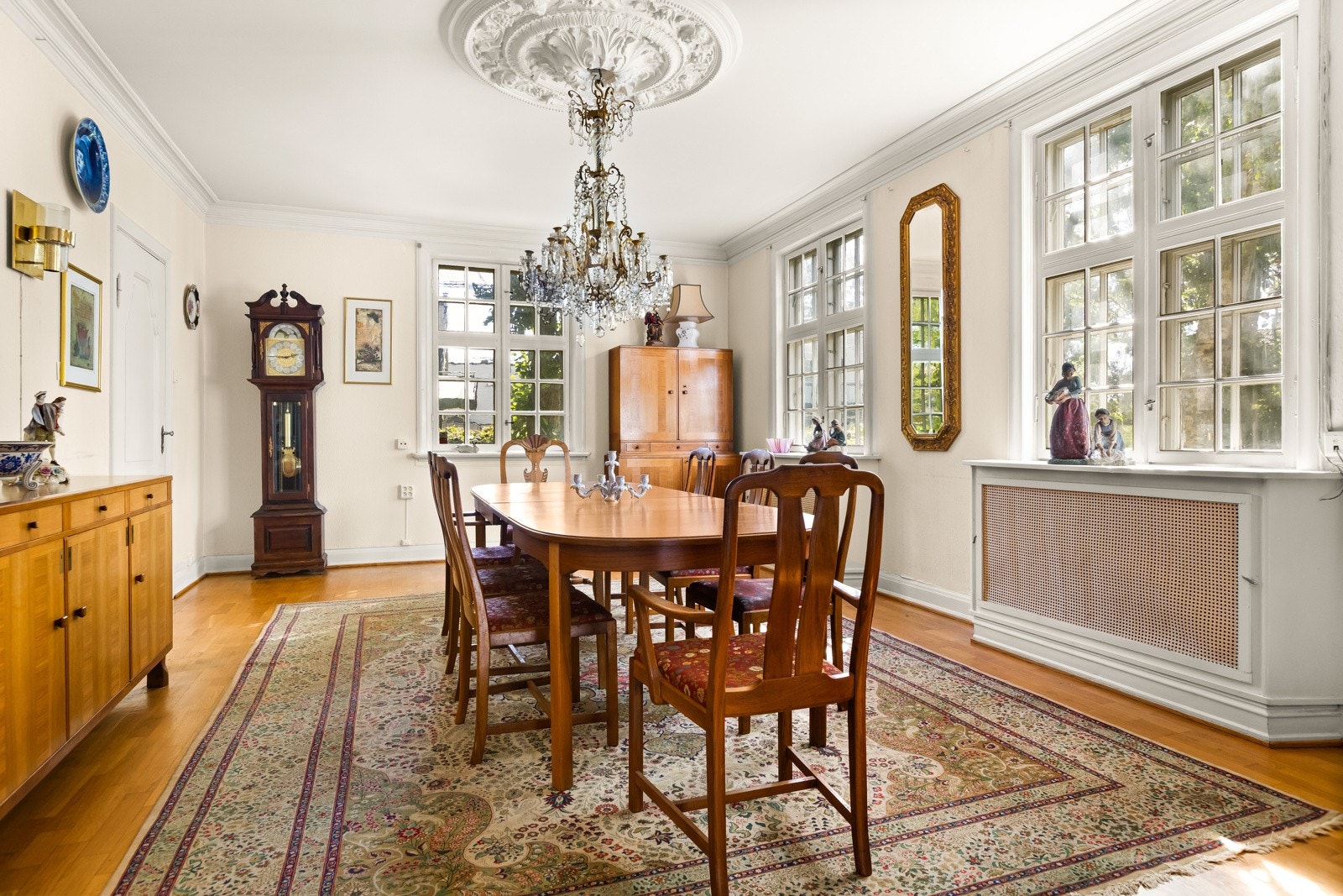 En vakker og romslig spisestue med klasiske detaljer som en flott kakkelovn og rosett i himlingen. Galleribilde