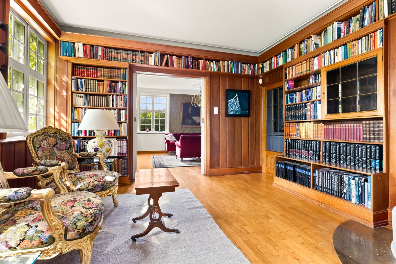 Forstuen har metervis med bokhyller og det er brede skyvedører mot spisestuen mot øst og stuen mot vest. Galleribilde