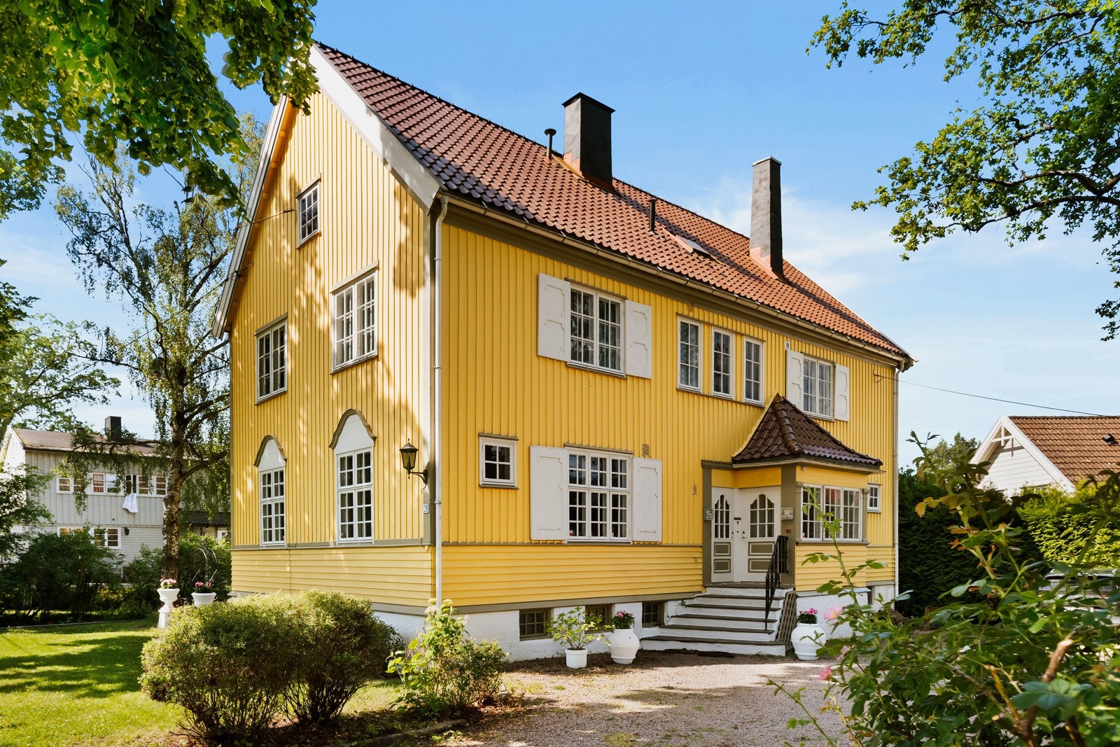 Gårdsplassen er gruslagt og har plass til flere biler utenfor garasjene. Galleribilde