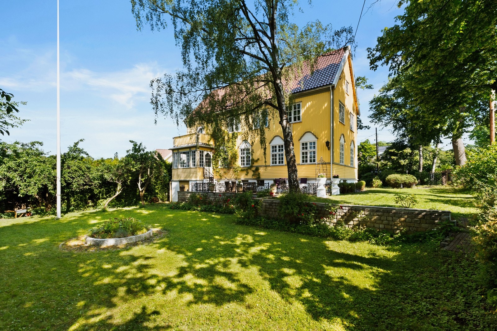 Den flotte tomten er omkranset av gjerde og hekk. Galleribilde