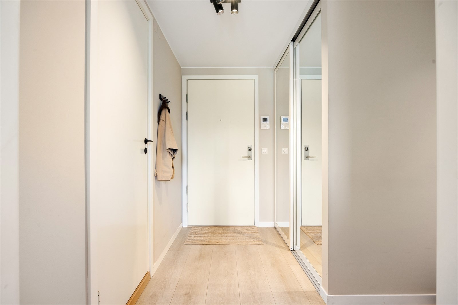 Leiligheten har en innbydende entré som skaper et umiddelbart godt førsteinntrykk. Det er god plass til oppbevaring av yttertøy i den romslige skyvedørsgarderoben med speilfronter. Galleribilde