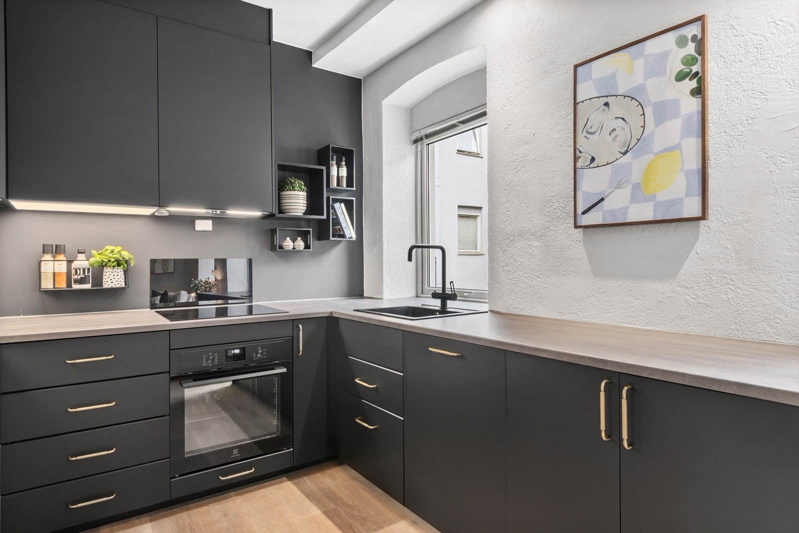 Kjøkkeninnredning med mørke fronter og en moderne utførelse som skaper et gjennomført preg på rommet. Galleribilde