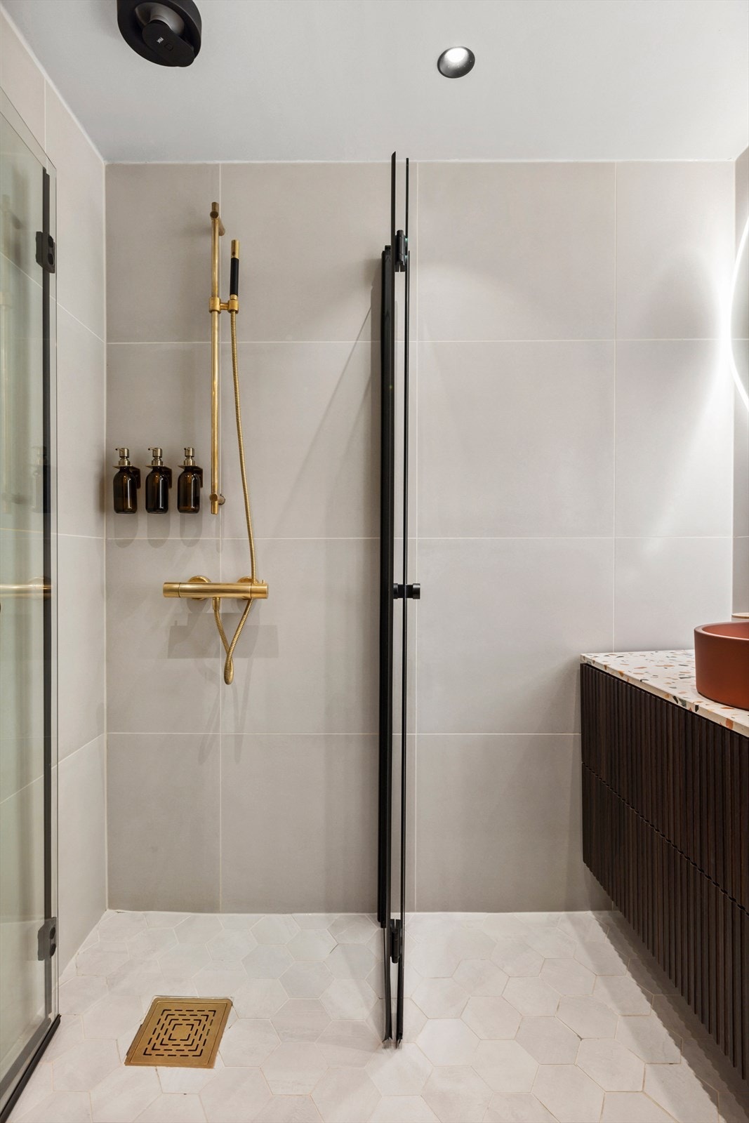 Lekkert bad der gullfarget armatur og sort dusjhjørne skaper en elegant kontrast. Galleribilde