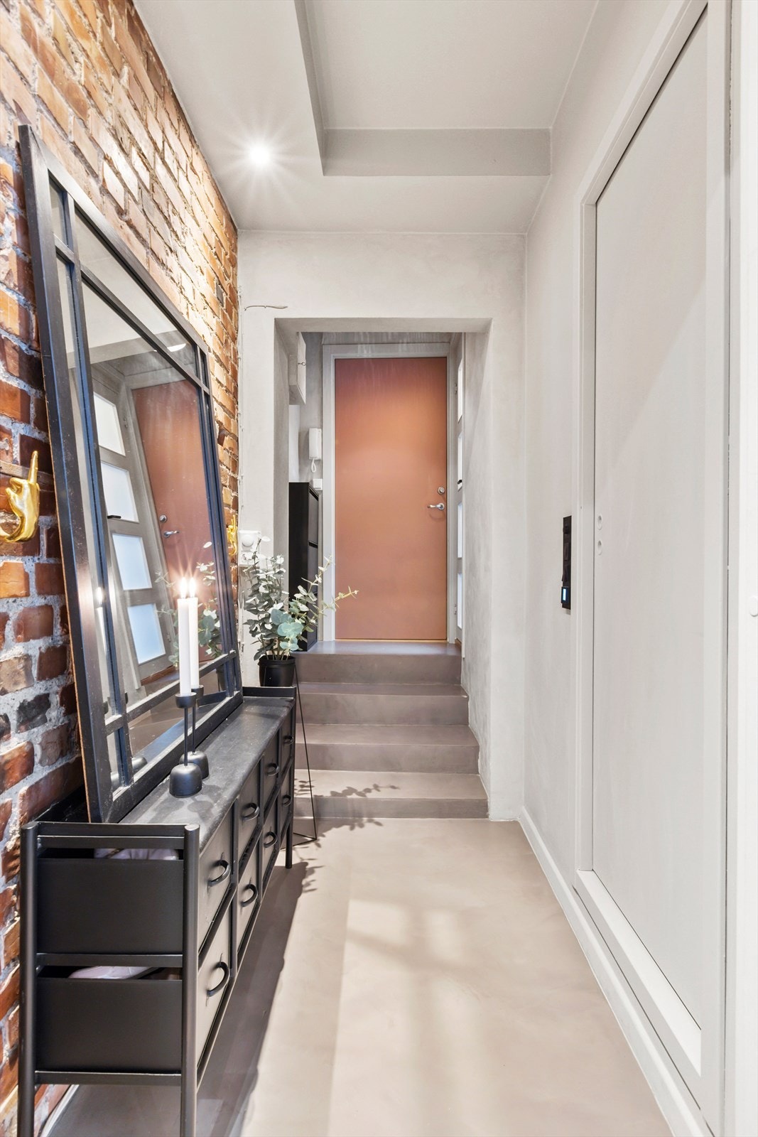 Entréen skaper en særegen atmosfære, der en liten trapp leder videre inn i leiligheten. Galleribilde