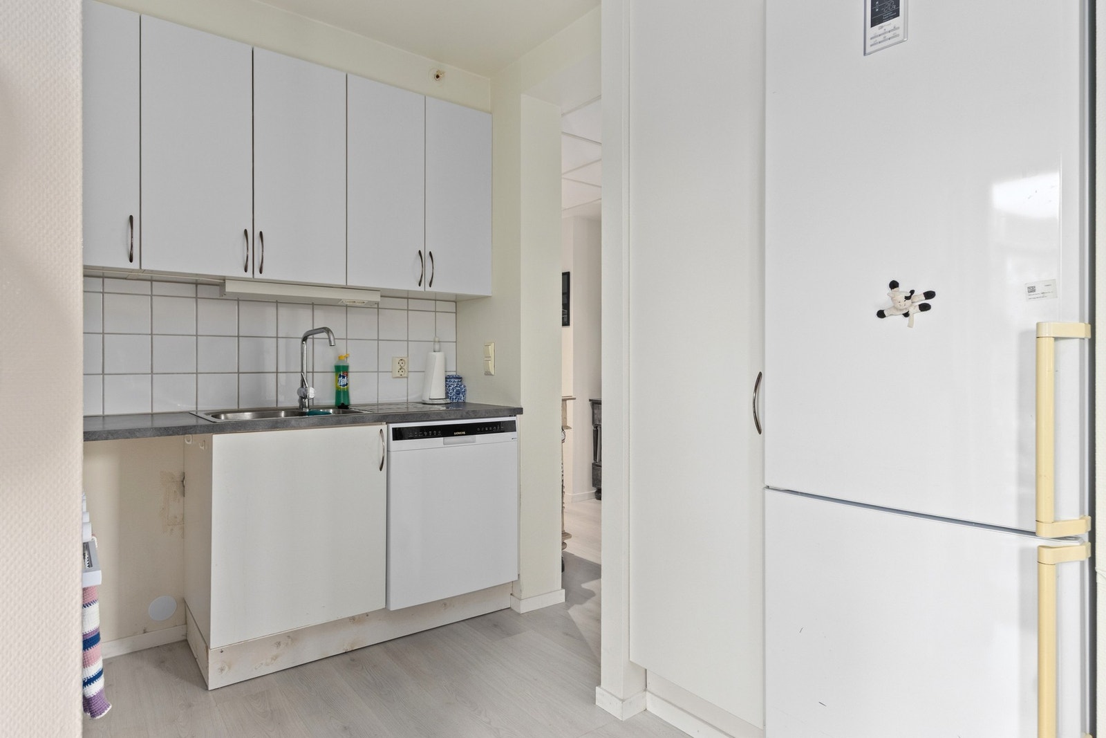 Kjøkken med avsatt plass og opplegg for oppvaskmaskin, komfyr og et kjøleskap. Galleribilde