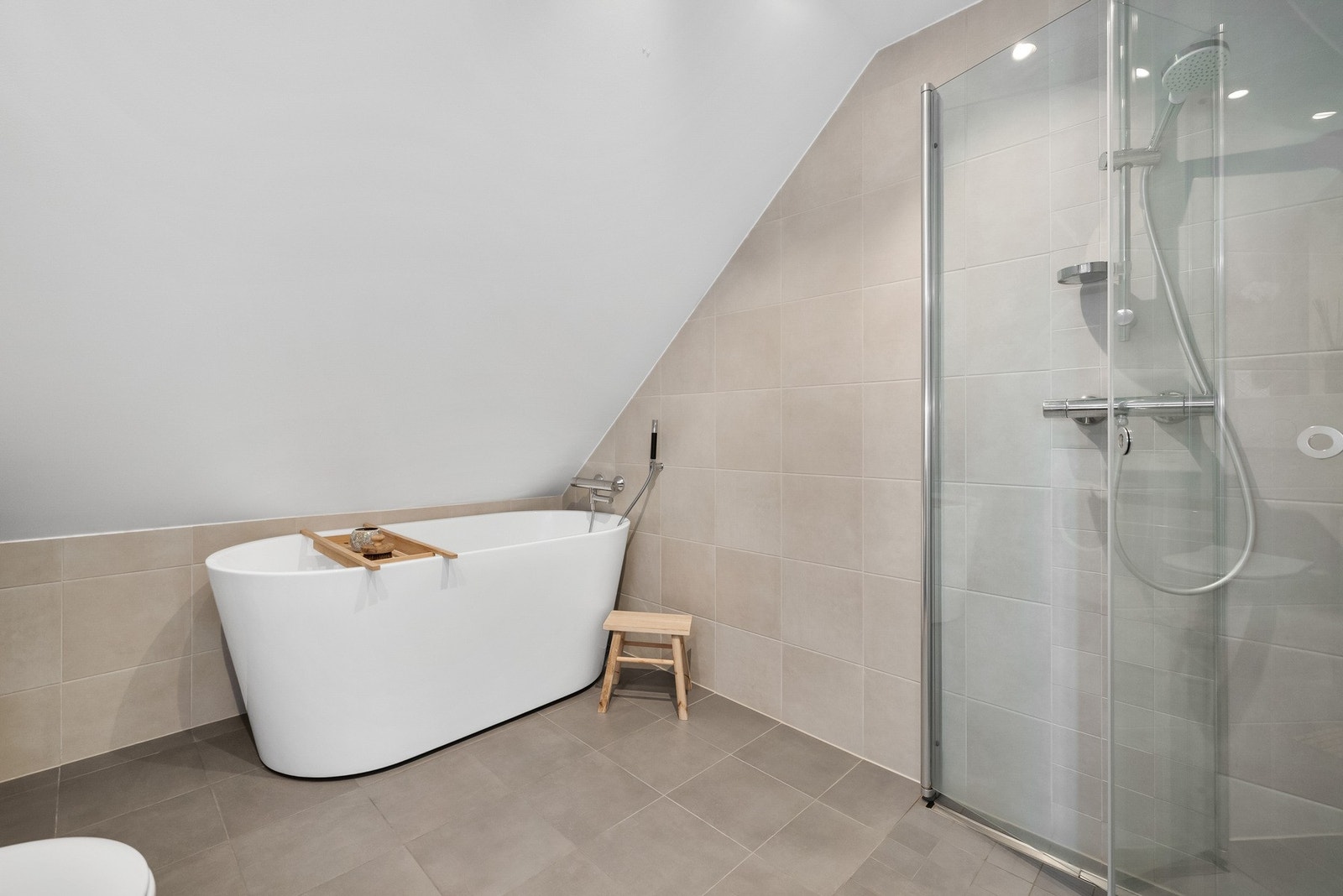 Badet har et frittstående badekar og dusj med glassdør. Galleribilde