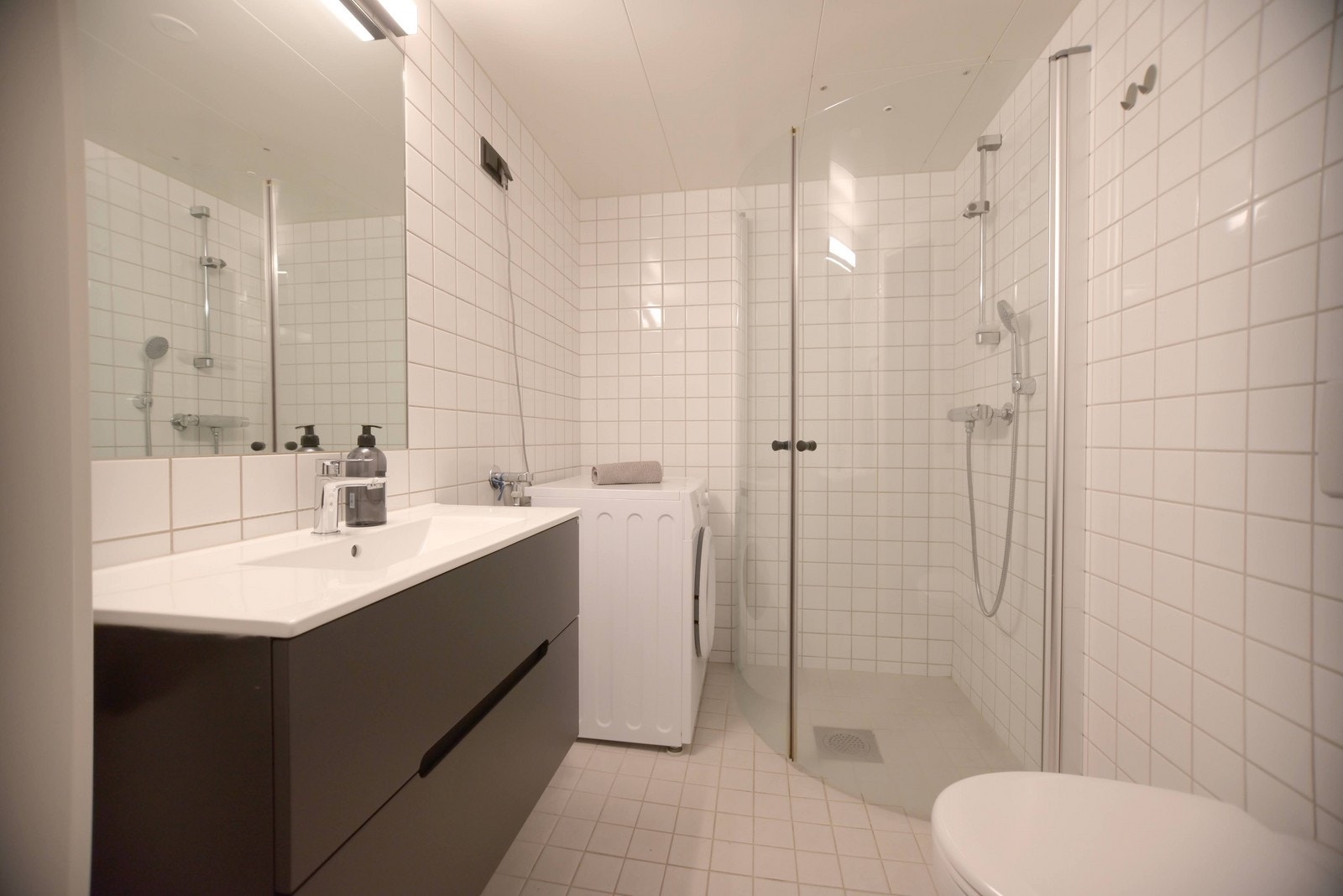 Flislagt bad med opplegg for vaskemaskin. Nyere innredning. Galleribilde