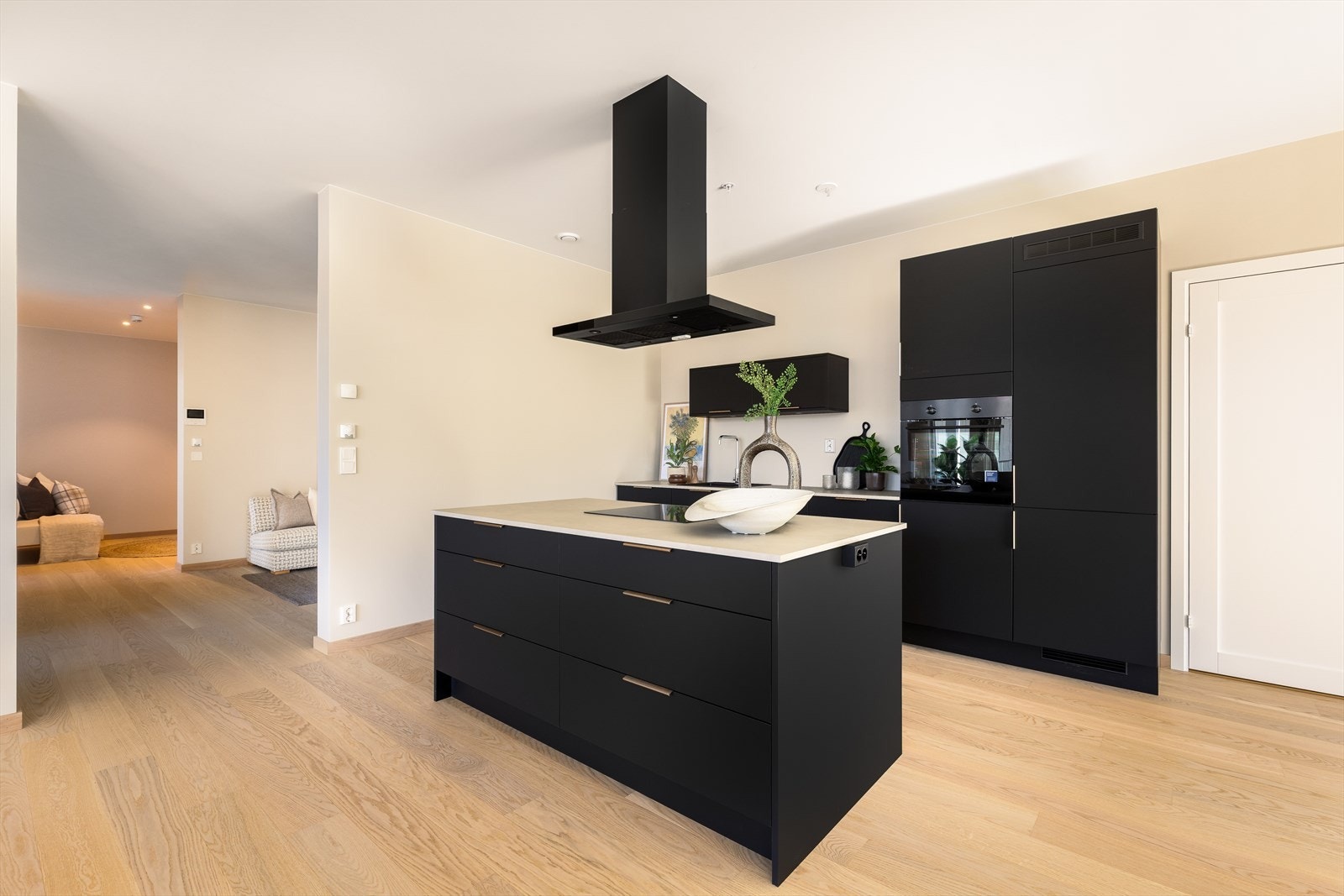 Praktisk kjøkkenøy med oppbevaring på begge sider fungerer som et naturlig skille mot stua. Galleribilde