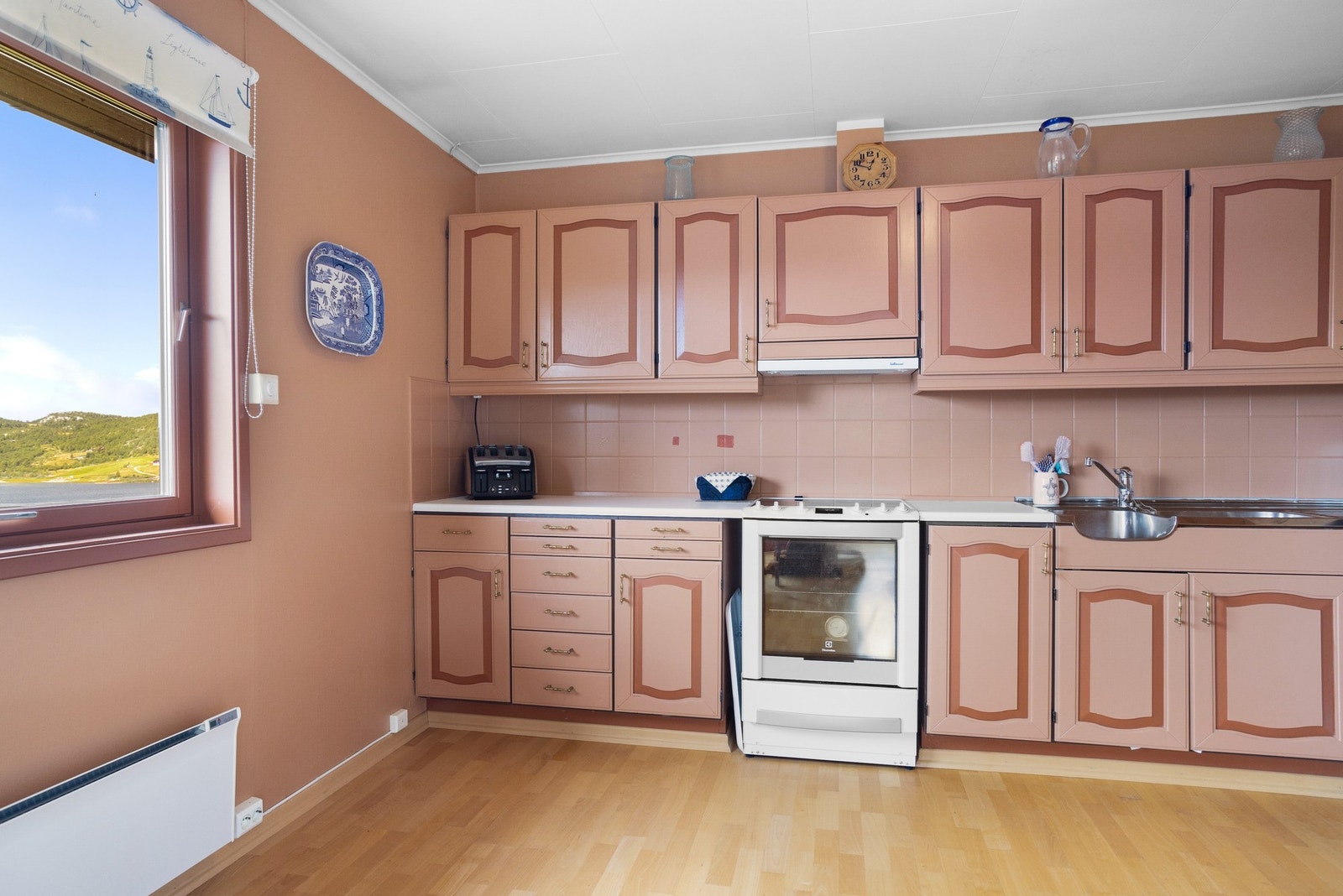 Kjøkken med innredning med profilerte fronter og benkeplate i laminat. Galleribilde