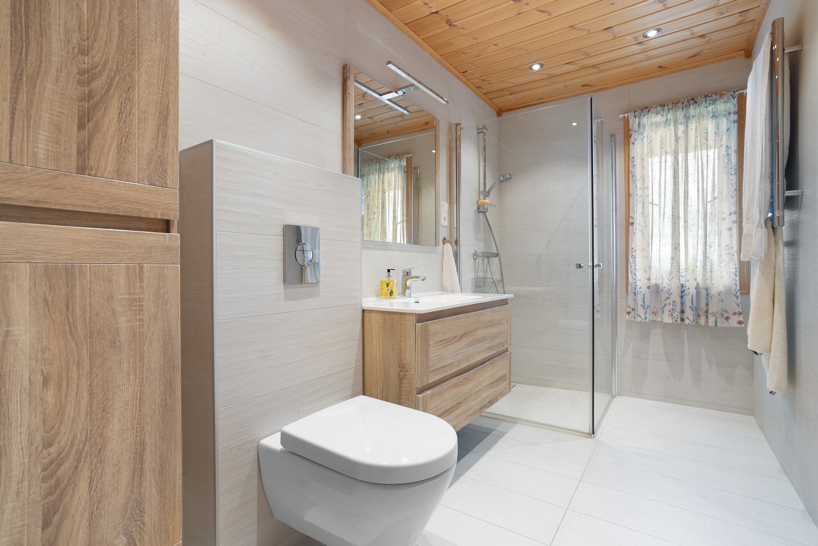 Baderom II er pusset opp i 2022. Moderne overflater og innredning. Baderommet inneholder veggmontert toalett, innredning med servant og dusjhjørne med glassdører. Galleribilde