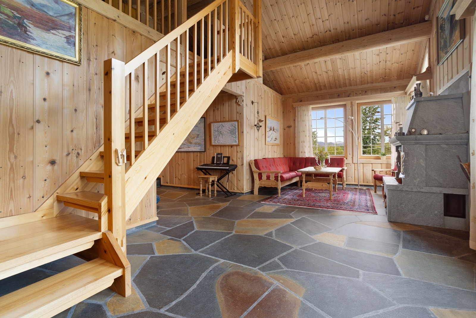 Romslig hall med stuedel. Her er det skiferbelagt gulv og panel på vegg som gir den skikkelig gode fjellhytte-følelsen. Galleribilde