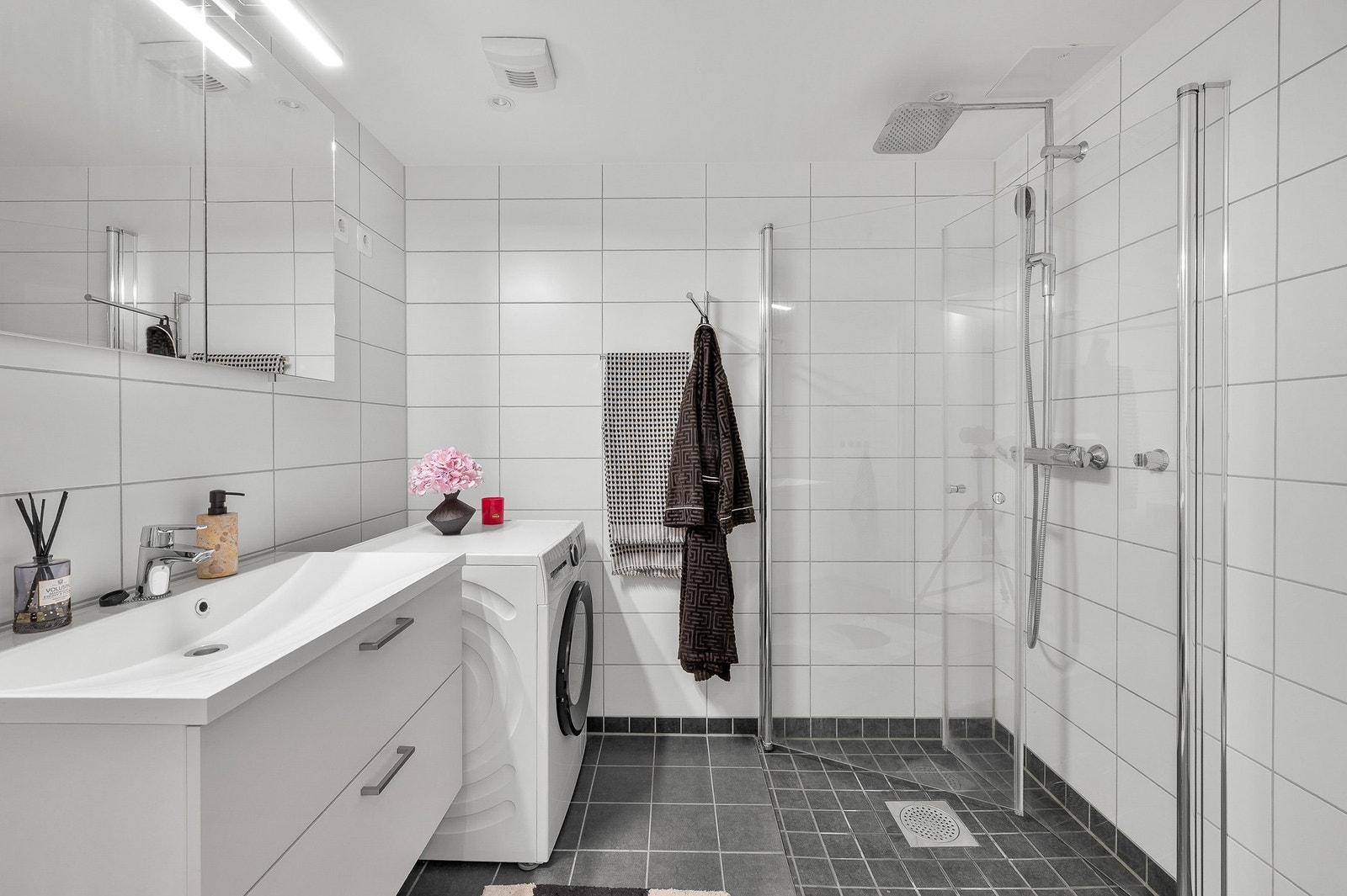 Bad med regnfallsdusj og opplegg for vaskemaskin. Galleribilde