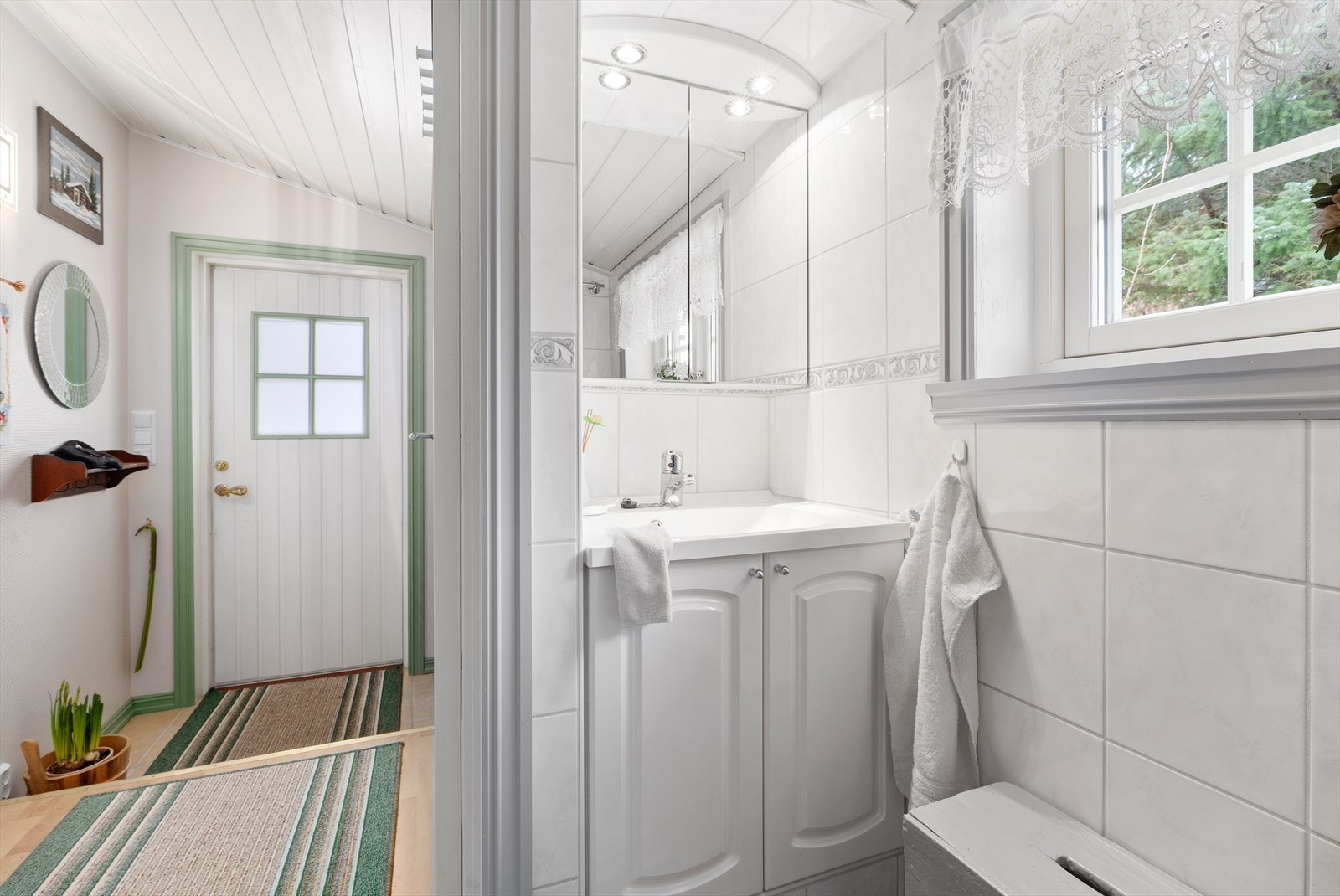 Badet er helfliset og er utstyrt med baderomsinnredning, wc og vegghengt dusj med dusjvegger Galleribilde