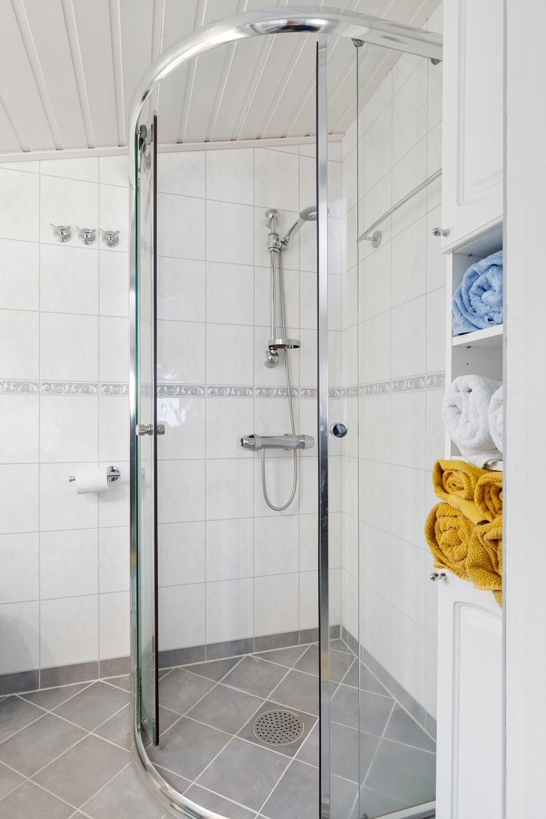 Badet er helfliset og er utstyrt med baderomsinnredning, wc og vegghengt dusj med dusjvegger Galleribilde