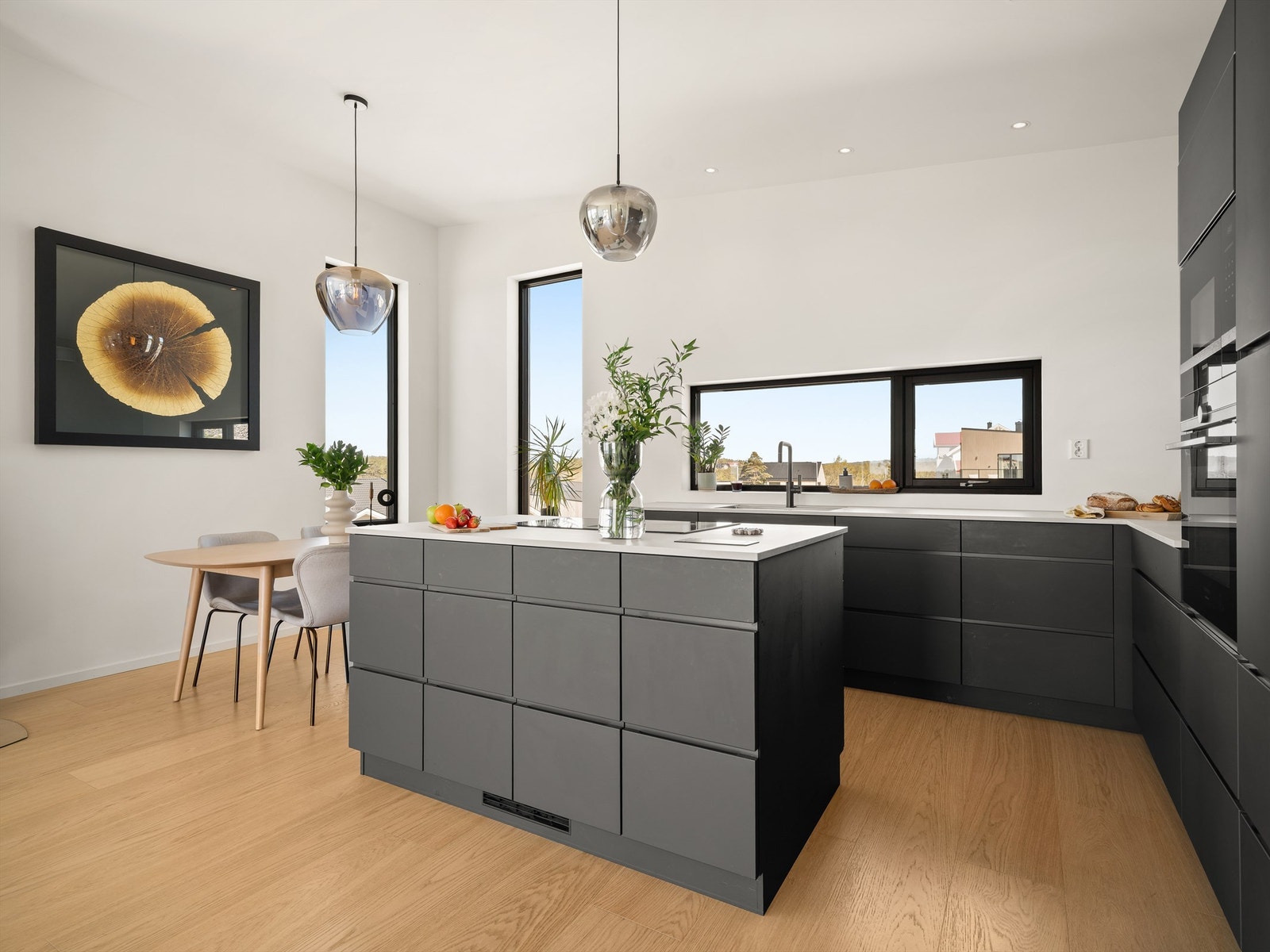 Kjøkkenets hvitevarer er alle integrert, platetopp med avtrekk i den frittstående øyen. Galleribilde