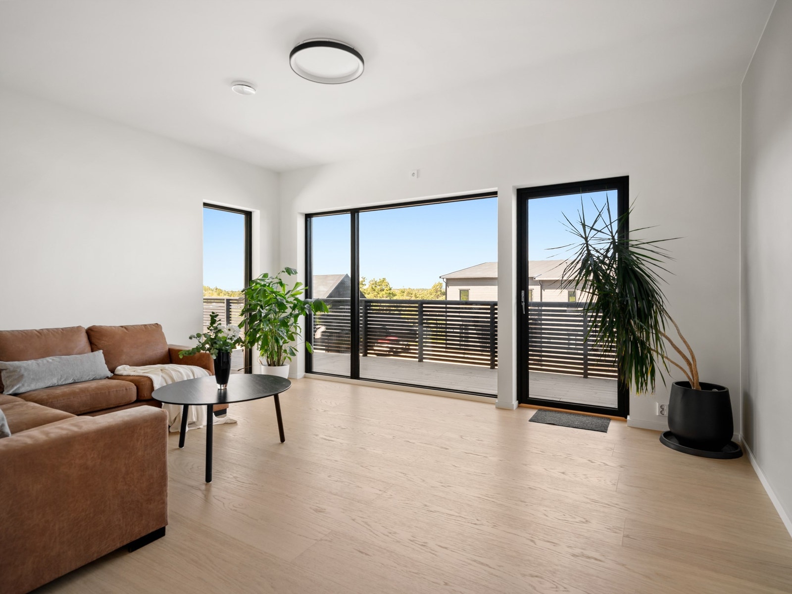 Boligens eleverte plassering sikrer fin utsikt også i sokkeletasjens stue. Galleribilde