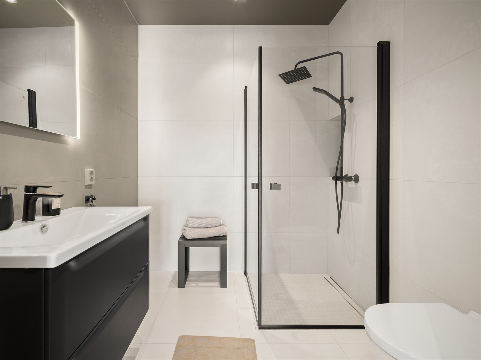 Sokkeletasjens soverom har praktisk nærhet til eget bad. Møbler og sanitærutstyr i samme serie danner en interiørmessig rød tråd mellom badene. Galleribilde