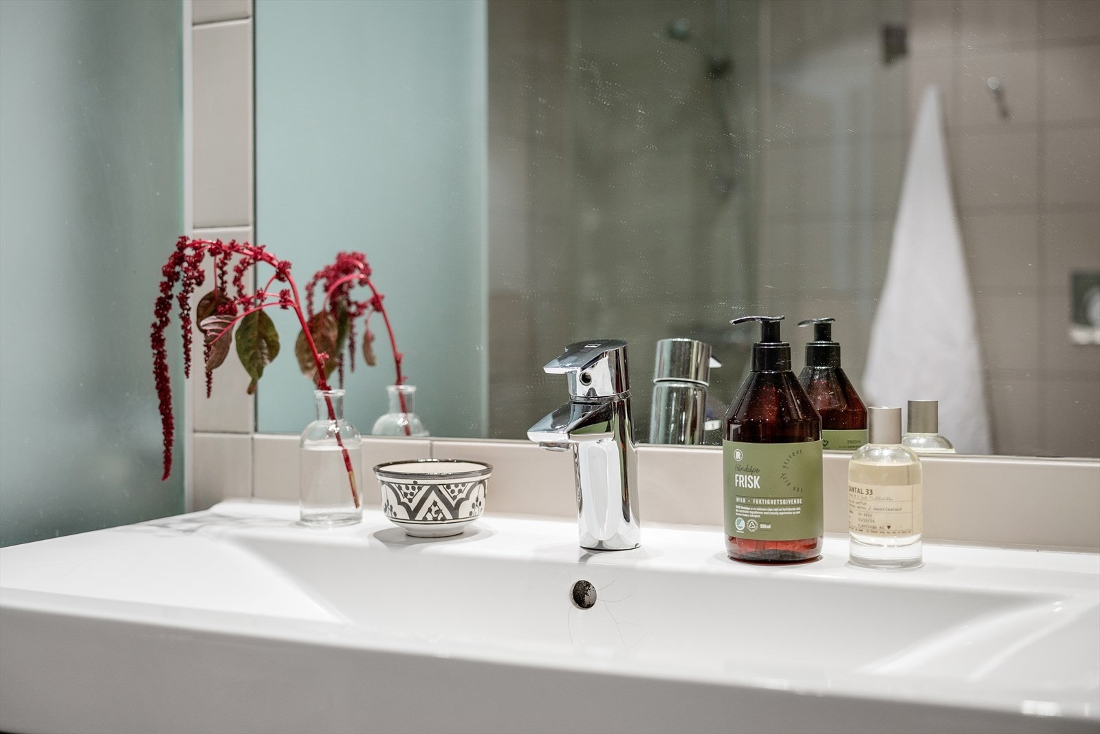 Badet er innredet med servant med underskuffer og speil. Galleribilde