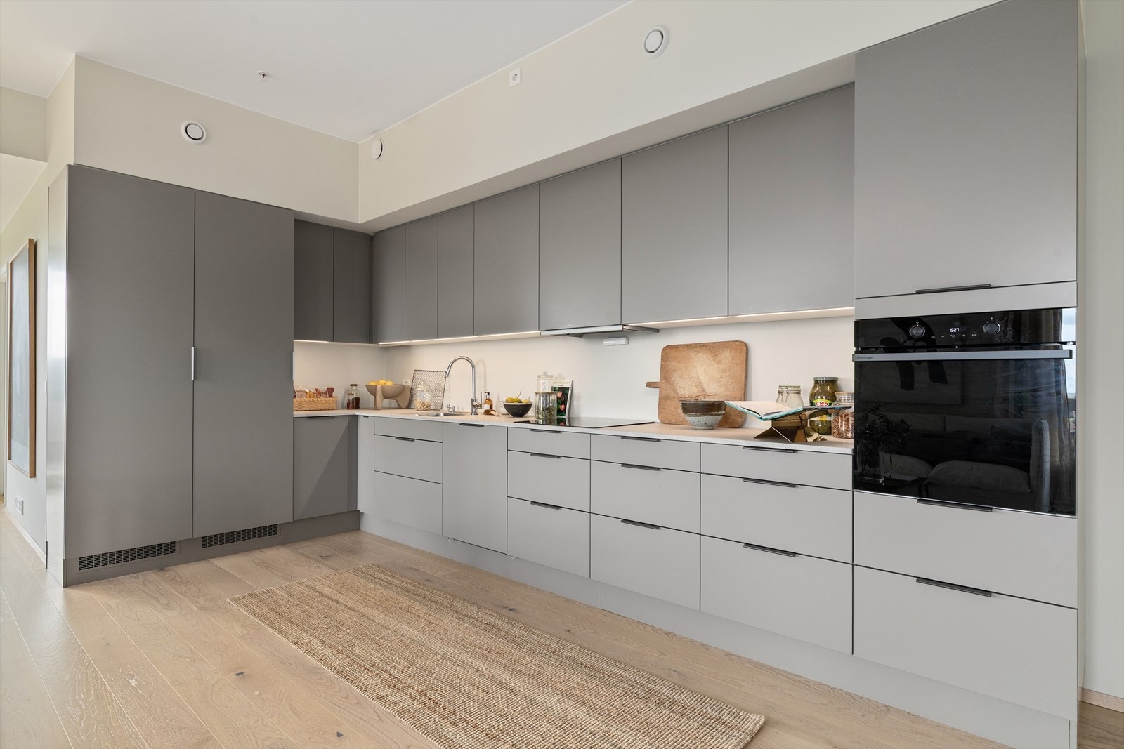 Romslig og påkostet kjøkken med følgende integrerte hvitevarer: kjøleskap, fryseskap, oppvaskmaskin, stekeovn og induksjon platetopp. Galleribilde