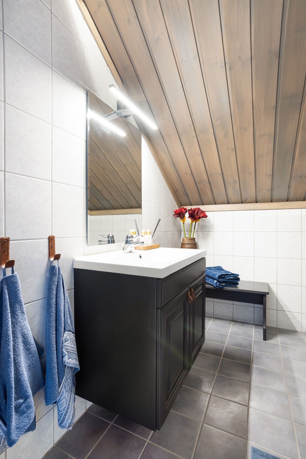 Flislagt bad i 2.etasje med nøytrale farge på flisene. Rommet inneholder servant, speil, vegghengt toalett og dusjnisje med glassvegger. Galleribilde