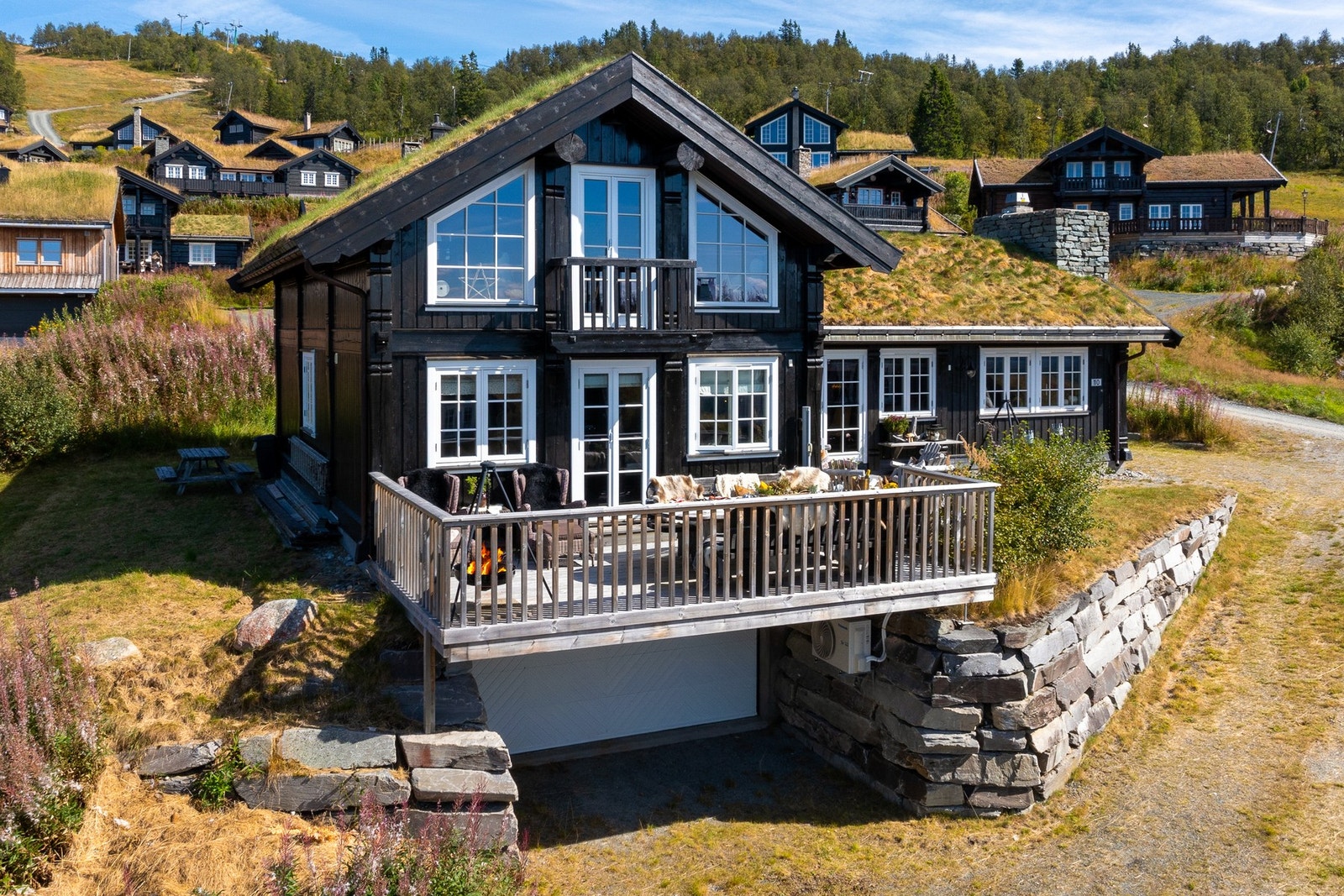 Svært påkostet tomt med natursteinsmurer og dobbel garasjekjeller. Garasje i underetasjen på hytta med direkte adkomst videre inn i hytta Galleribilde