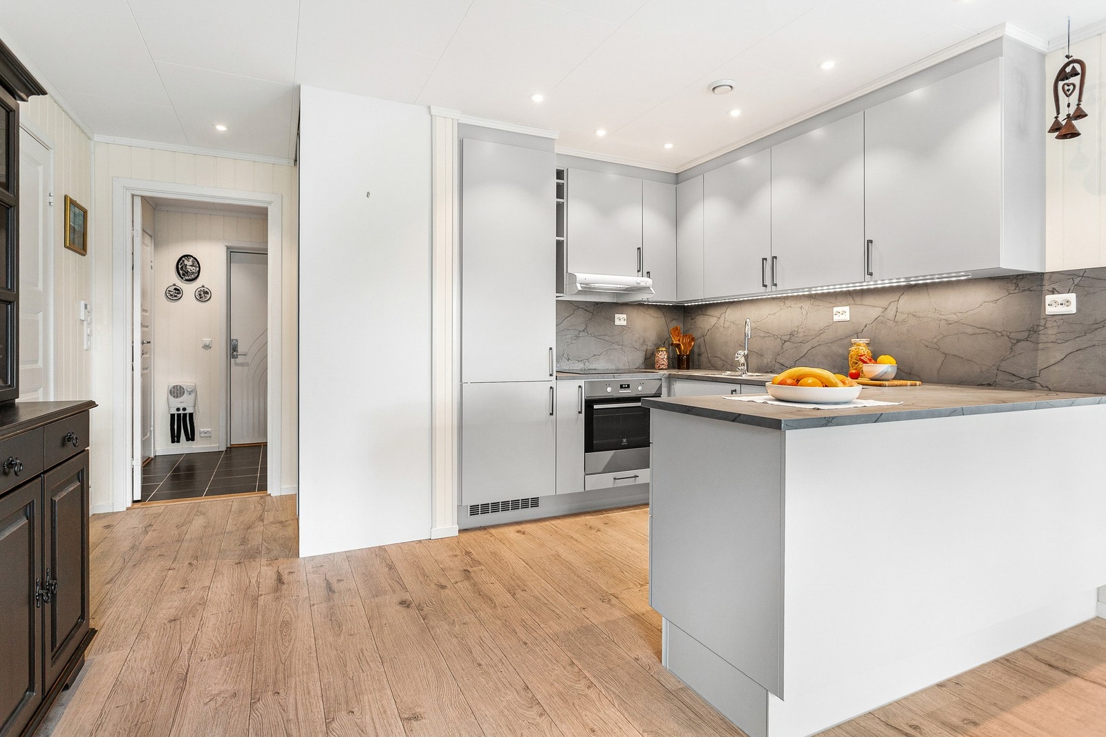 Kjøkkenet har åpen løsning til stue med en innbydende og luftig atmosfære. Kjøkkenet har integrerte hvitevarer. Galleribilde