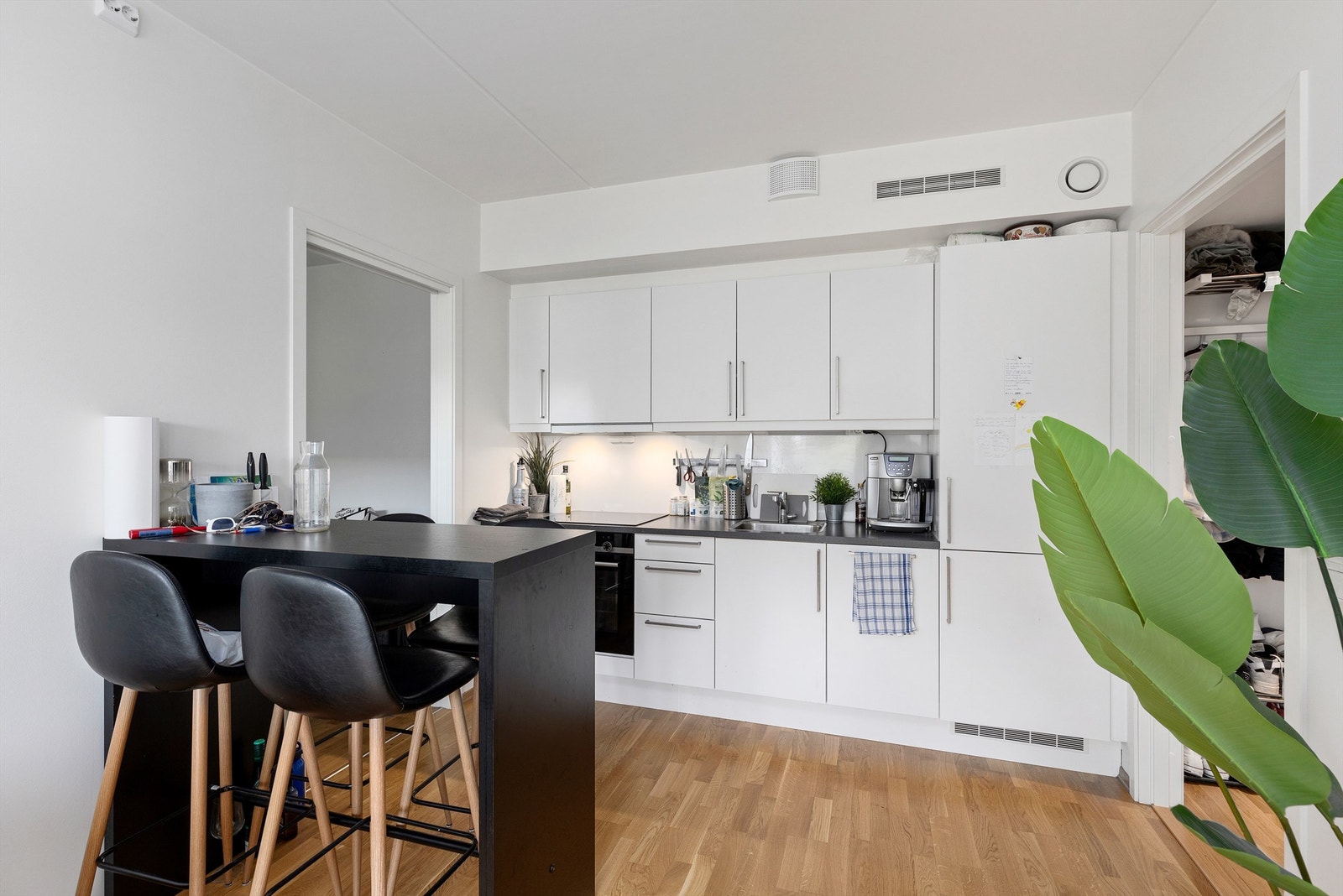 Kjøkkenet ligger naturlig tilbaketrukket fra stuen og er innredet med tidløs innredning med lyse slette flater og benkeplate i kontrast. Galleribilde