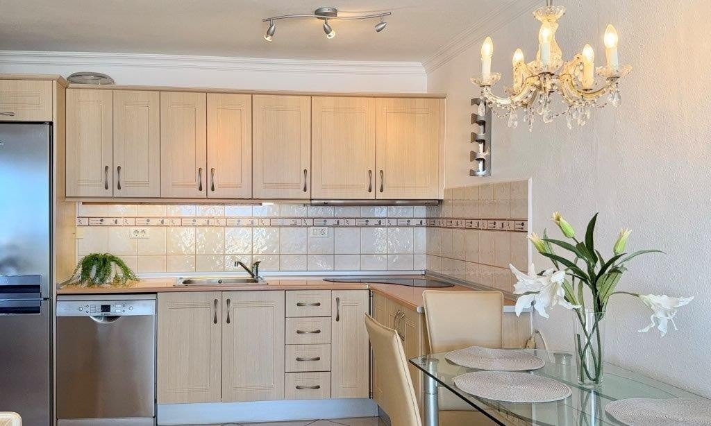 Kjøkkenet har komfyr, fancy kokeplater, oppvaskmaskin, kombiskap og masse skapplass Galleribilde