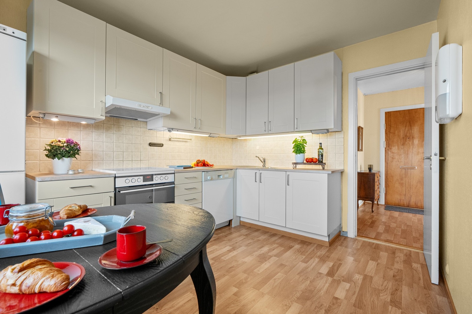 Innredningen har slette fronter og stålvask. vitevarene består av frittstående kjøle/fryse-skap, komfyr og oppvaskmaskin. Galleribilde