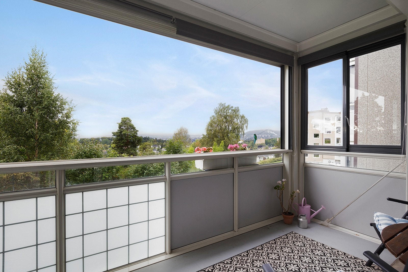 Balkong med god plass til sittegruppe, diverse møbler og planter. Galleribilde