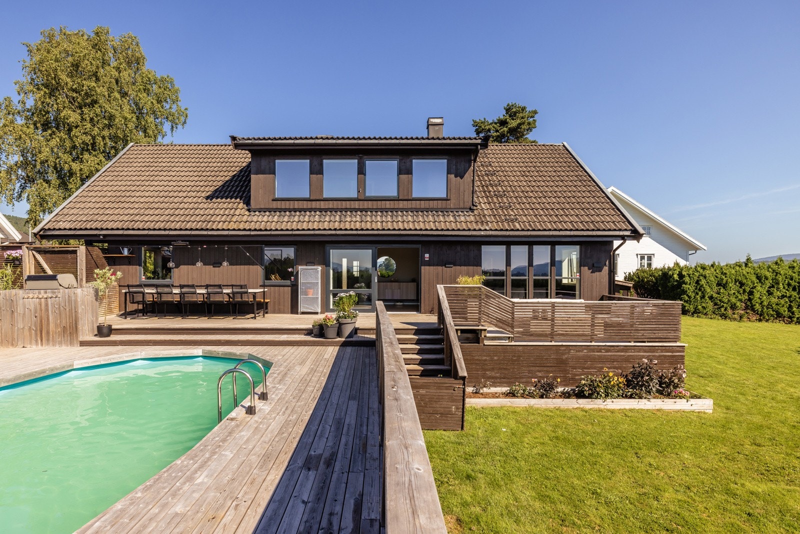 Pent opparbeidet tomt med bl.a. terrasse-/bassengområde og en flat og romslig gresseplen Galleribilde