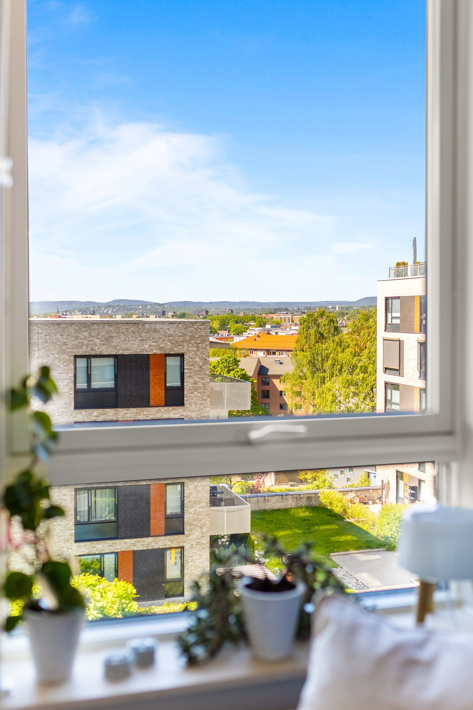 Vakkert utsyn fra 5. etasje over grønne omgivelser, by og fjell. Galleribilde