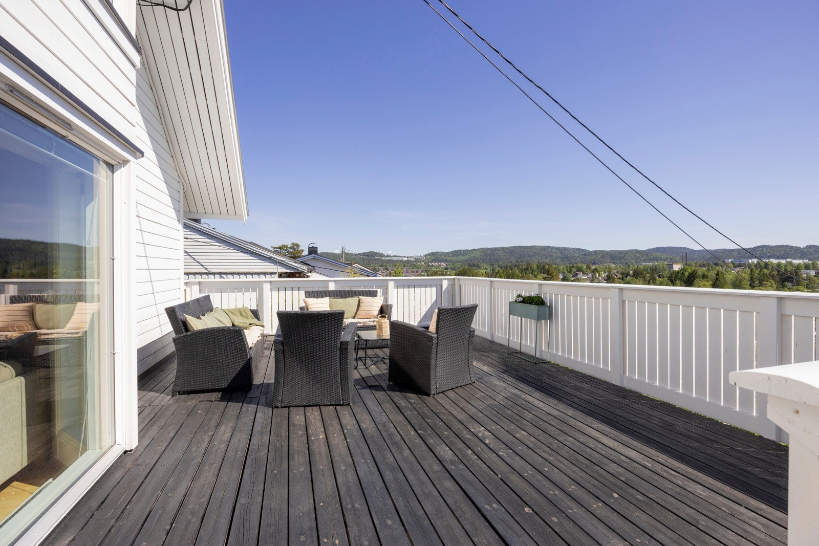 Langs husveggen og i front av boligen ligger en romslig og solrik terrasse med mange bruksområder. Galleribilde