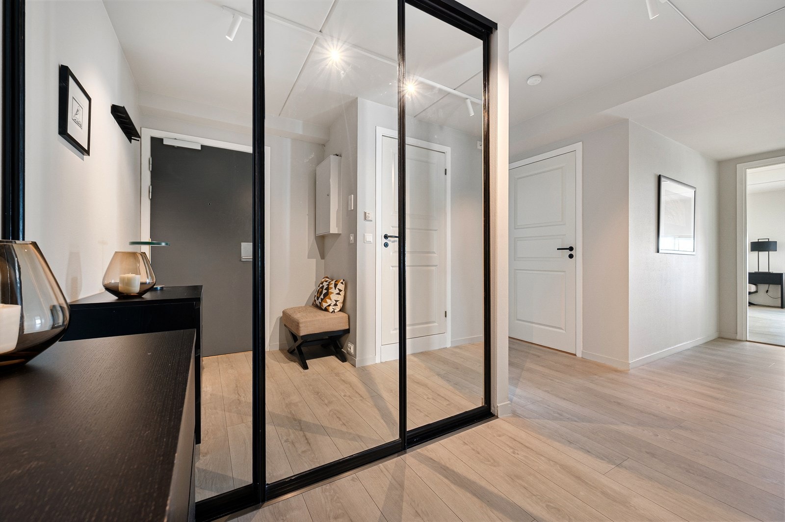Inngangspartiet er luftig og lyst, med gjennomgående enstavs gulv fra 2017 i alle tørre rom. Her finner du en praktisk skyvedørsgarderobe med speil og god oppbevaringsplass. Galleribilde