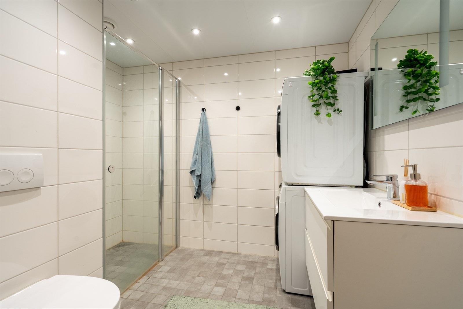 Dusjnisje i hjørnet gir badet ekstra plass, opplegg for både vaskemaskin og tørketrommel. Galleribilde