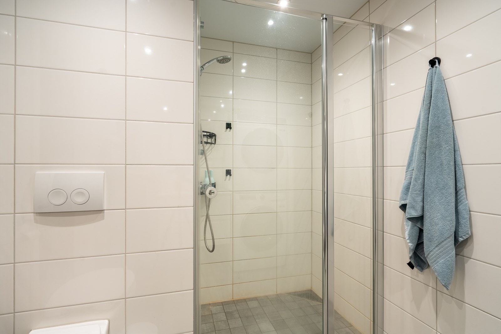 Stilrent, flislagt bad i lyse toner. Galleribilde