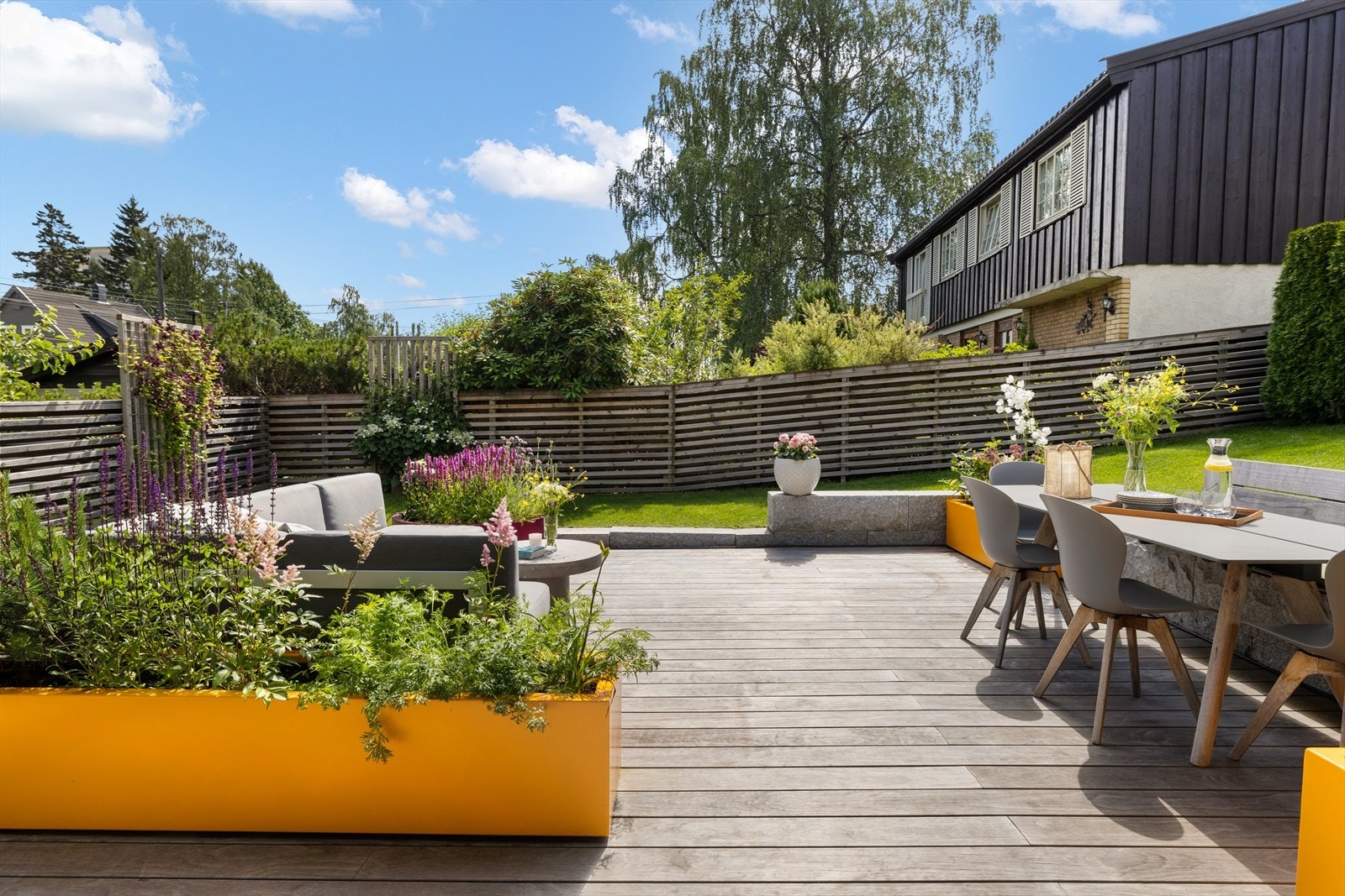 Pent opparbeidet hage med terrasseplatting og støttemurer Galleribilde