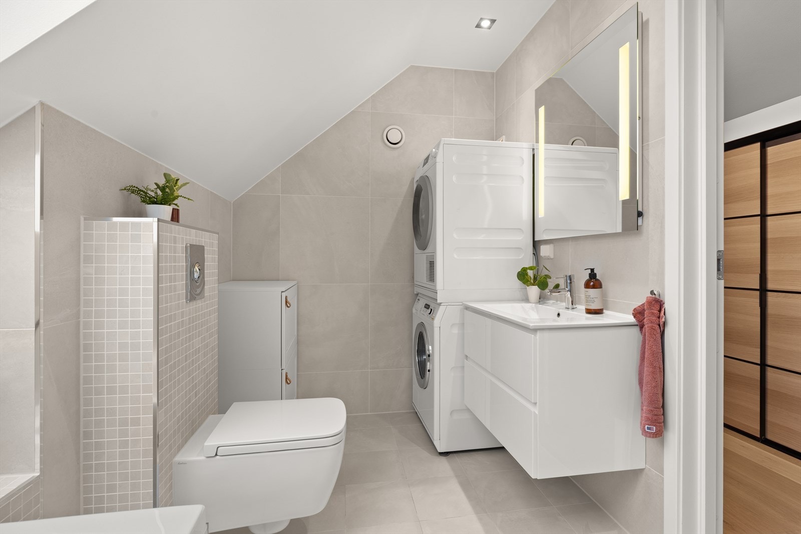 Lekkert og flislagt baderom med mye naturlig lyssinnslipp Galleribilde