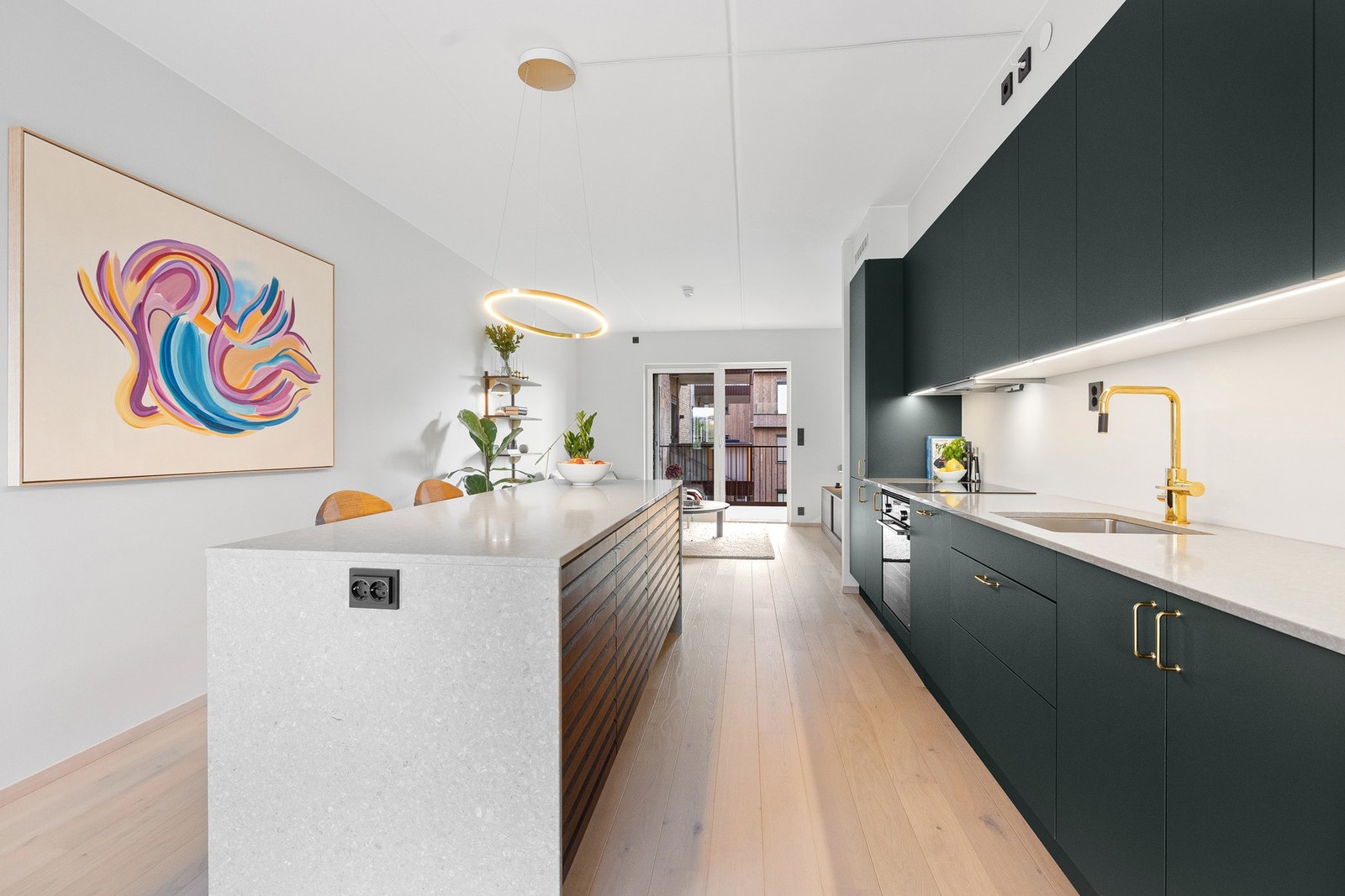 Planløsningen er godt tilrettelagt for å skape to naturlige soner, med kjøkkenet som et stilrent midtpunkt. Galleribilde