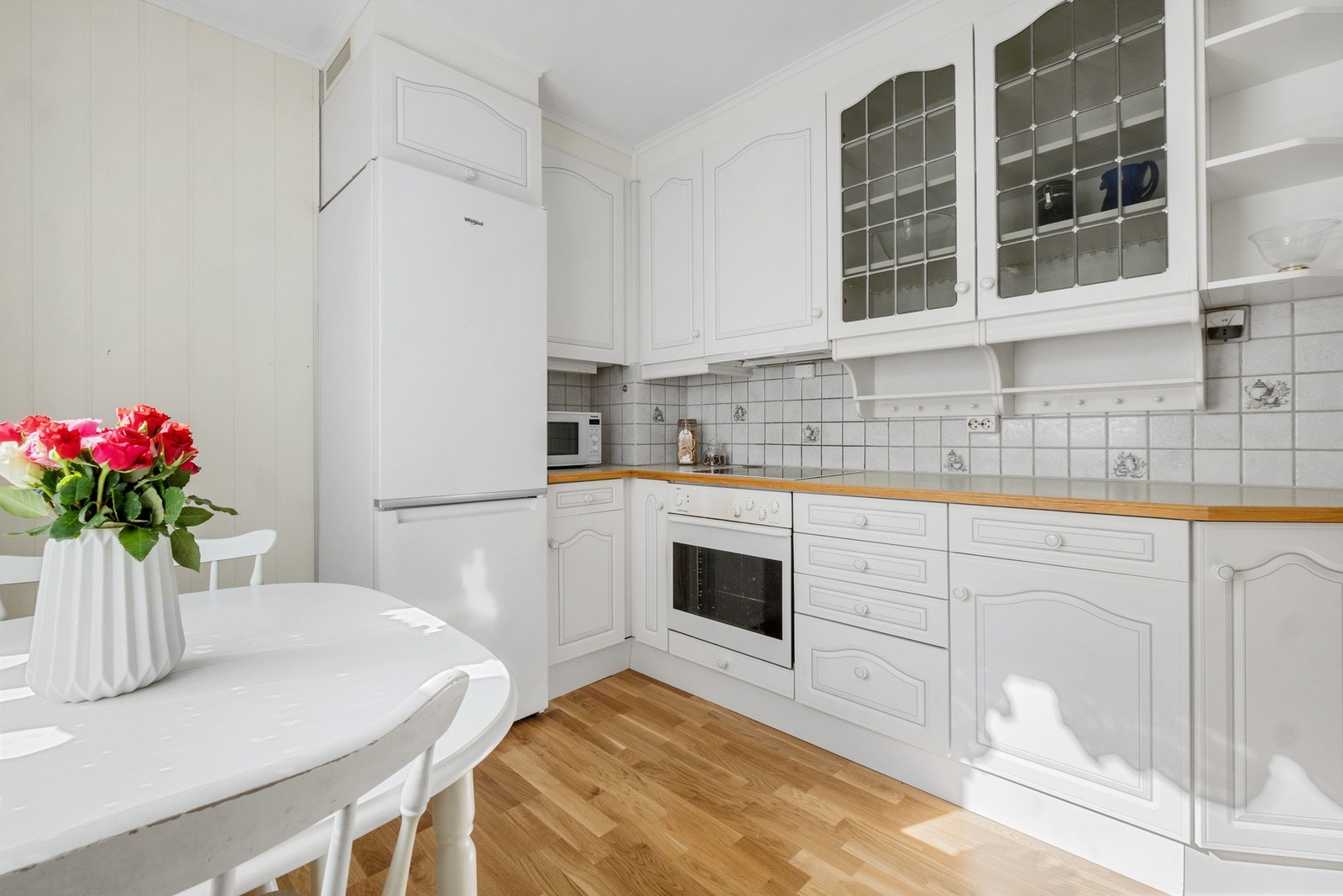 Boligens kjøkken ligger praktisk til i eget rom. Eldre kjøkken med stilrent preg. Modernisert med integrert stekeovn og platetopp. Galleribilde