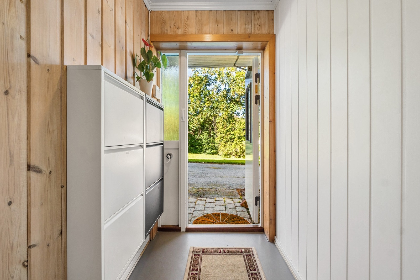 Innbydende vindfang med panel på vegg og belegg på gulv. Galleribilde