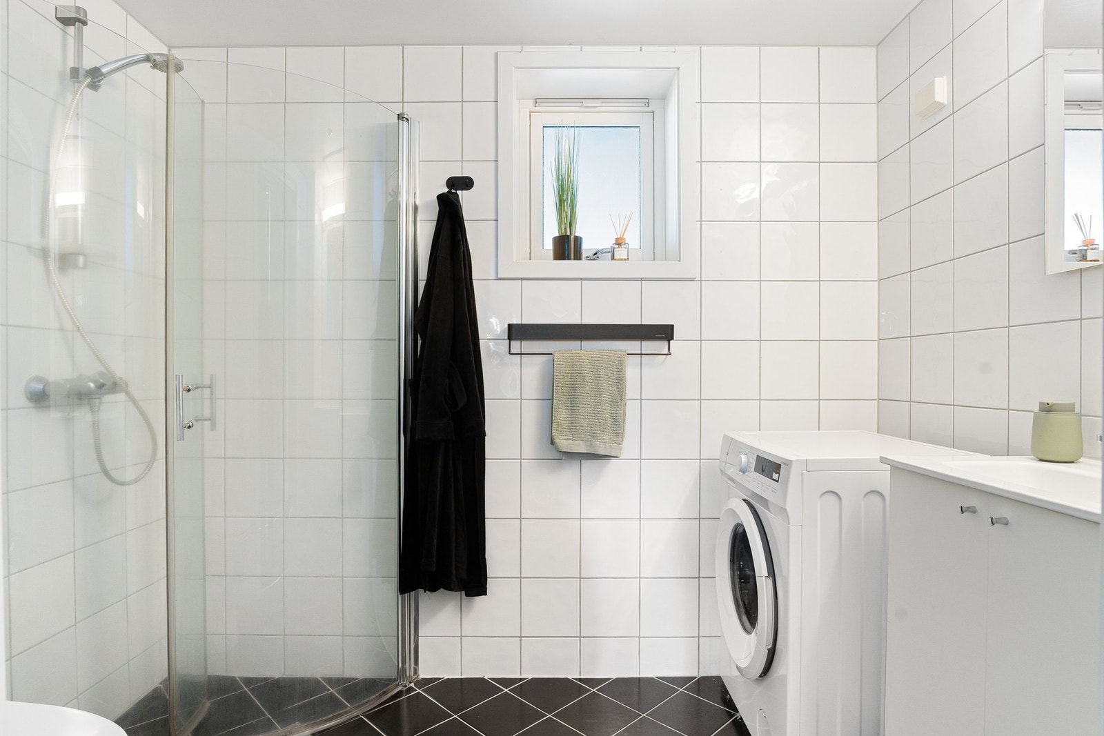 Baderom med flislagt gulv med varme. Dusjhjørne med innfellbare glassdører. Opplegg for vaskemaskin. Galleribilde